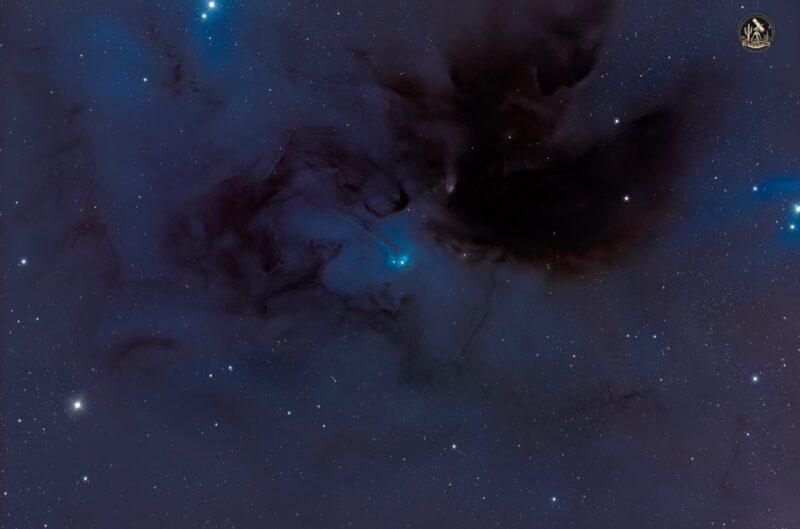 Deep-sky photos: Large blue swirls with dark lanes over a multitude of background stars.