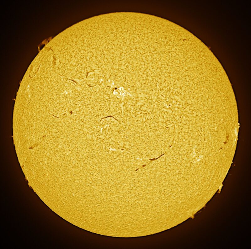 The sun, seen as a large yellow sphere with a mottled surface.
