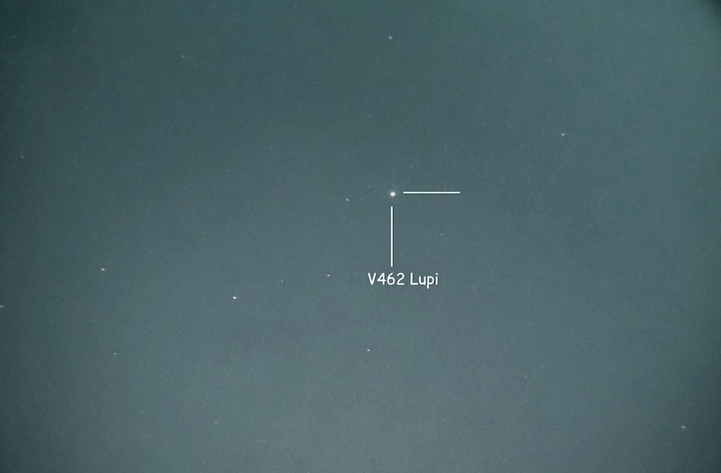 Darkish sky with a few stars showing and an annotated star marking the nova V462 Lupi in Lupus.