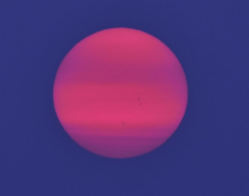 Pinkish sun with horizontal bands.