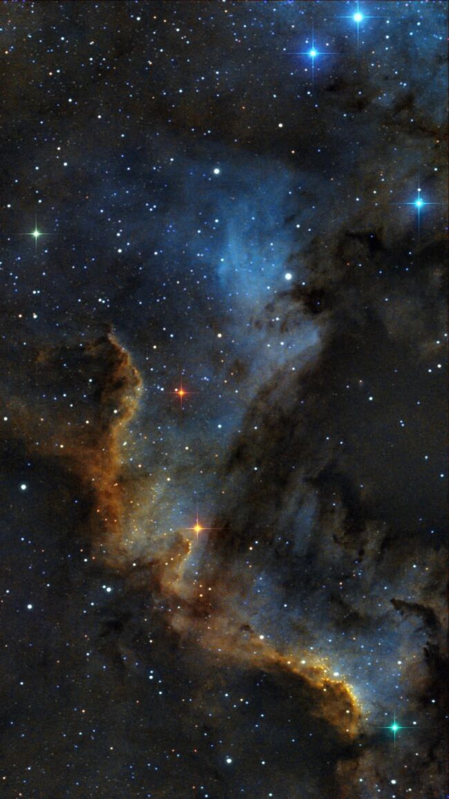 Large, orange and blue clouds with the shape of Mexico and numerous faint stars.
