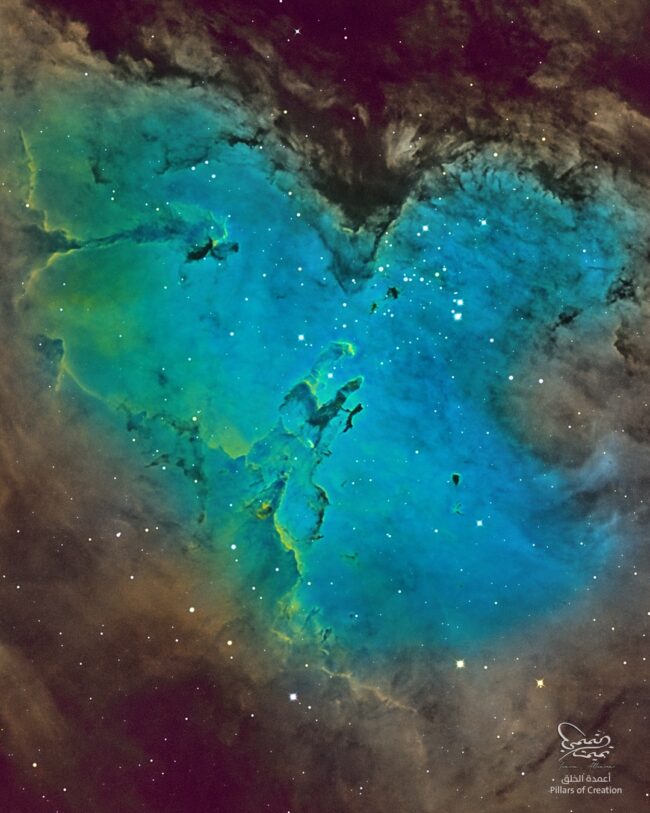 A bright green, nebulous region with dark lanes, over a rich background of stars.