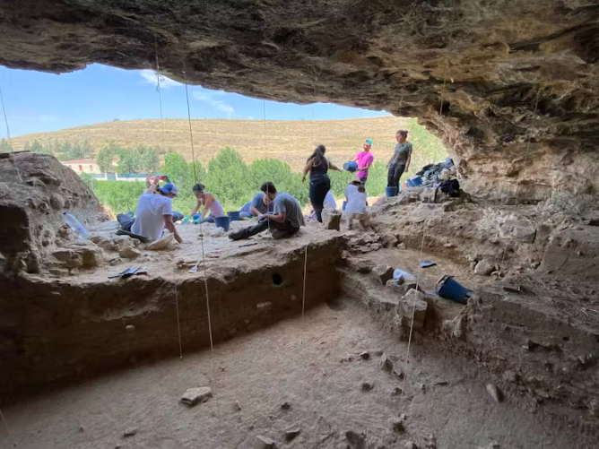 A group of around 10 people working on a cave. The image was taken inside the cave.