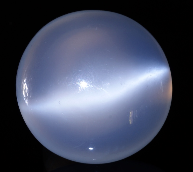 A smooth round jewel with a streak of light across it.