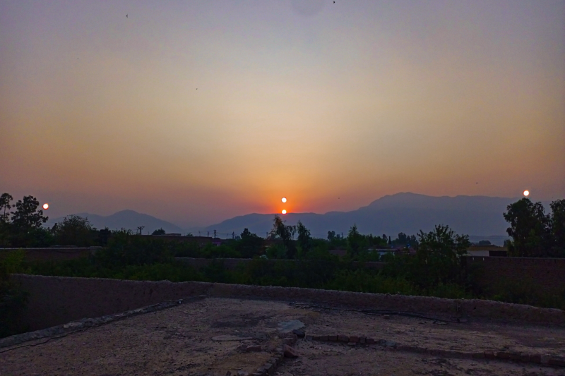 Mountain in the distance with 2 suns (orangish) in the front and other 2 (whitish) on the sides.