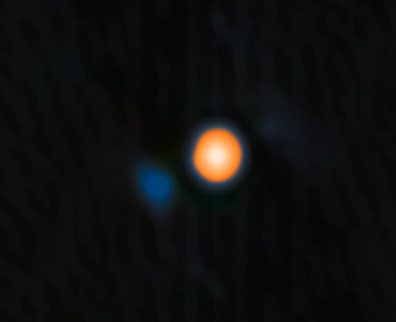 Companion for Betelgeuse: Bright reddish circle with white spot in the center, and smaller blue spot next to it on black background.
