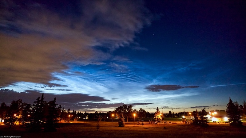 Glowing blue clouds above the horizon in the twilight sky.