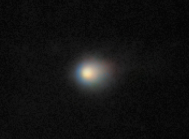 Alien spacecraft: Bright circular object in the middle with a fuzzy oblong halo around it.