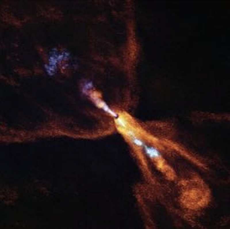 Streams of blue-and-orange material coming out of a central point in a spider-like pattern on a black background.