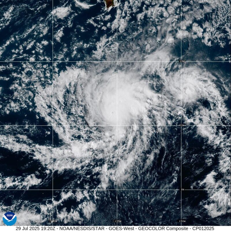 Hurricane Iona is a swirl of white clouds over the dark blue waters of the central Pacific Ocean. A small part of the big island of Hawaii at top, otherwise the storm is over open water.