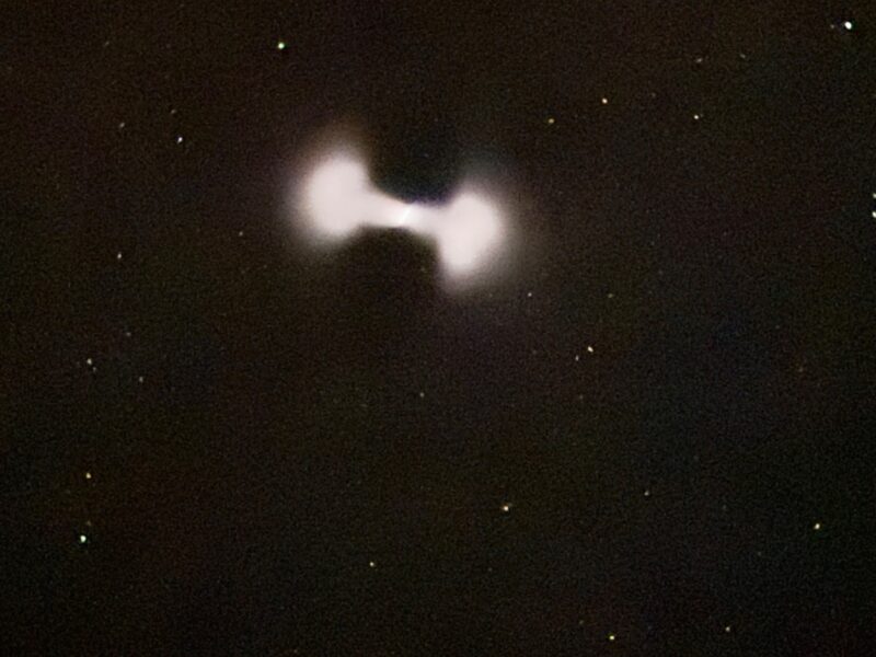 Dumbbell shaped light on a starry background.