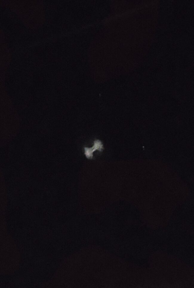 White double lobed object in black sky.