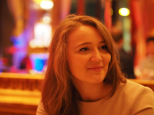 Smiling woman with long hair looking to the right.