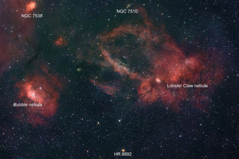 Large, cocoon-shaped region of orange gas with curved filaments and numerous foreground stars.