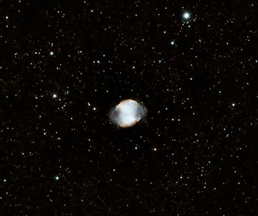 A small, dumbbell-shaped bluish cloud, with numerous background stars.