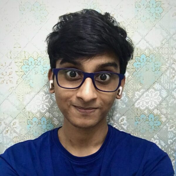 Very young man with lots of dark curly hair and glasses.
