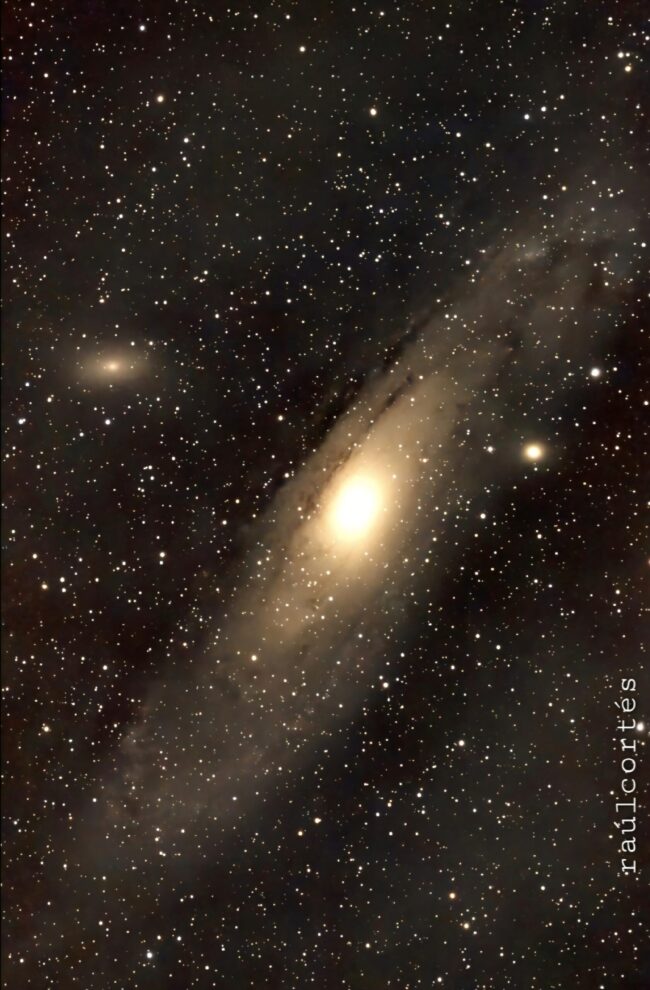 Starfield with an oblique spiral galaxy with a big bright spot at center.