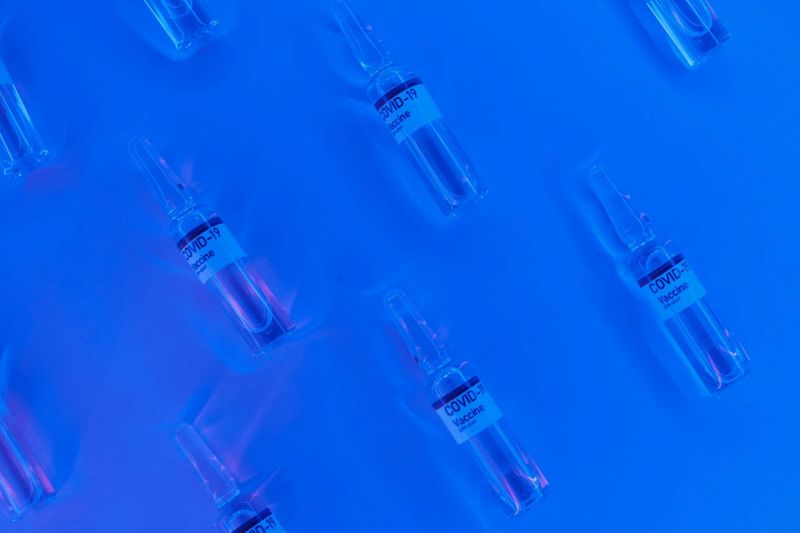 Covid vaccine: Vials labeled COVID-19 vaccine under a blue light.