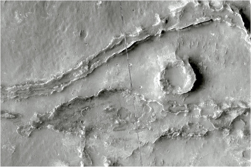 Gray terrain with long, meandering ridges and a smaller circular ridge next to them.