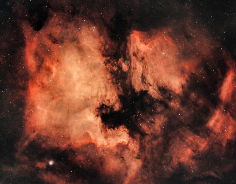 Велики, наранџасти облаци са обликом Северне Америке и бројним слабим звездама.