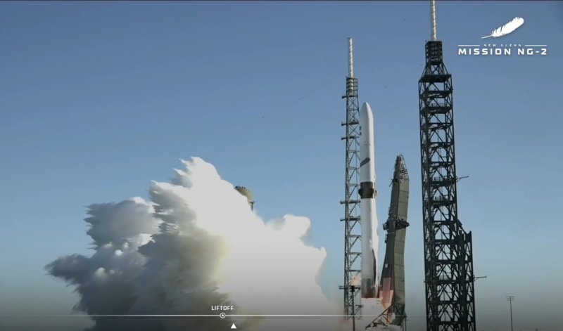 A rocket starts to lift upward over a plume of white steam as the arm falls away.