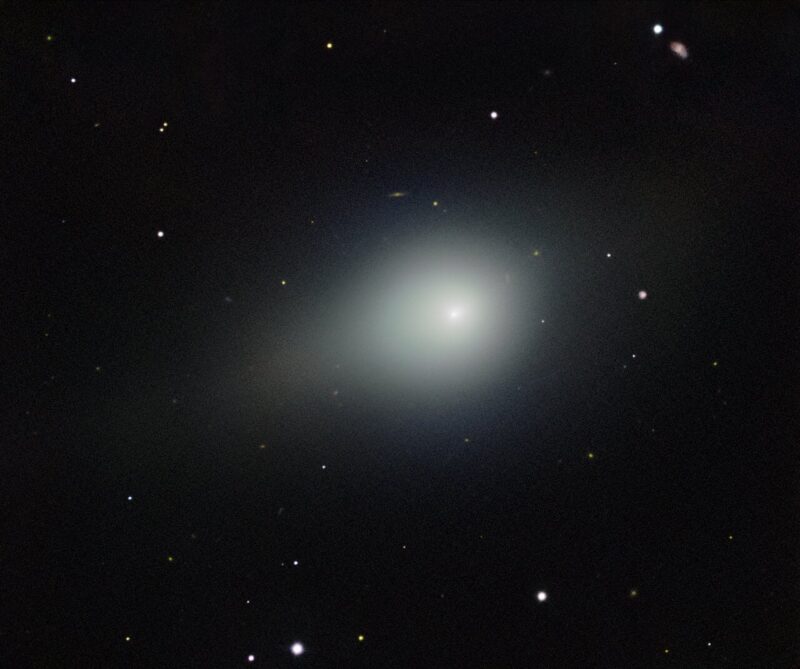 A fuzzy object with a bright core and a stubby tail, stars and galaxies in background.