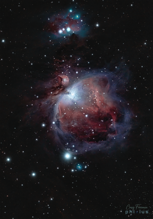 Велики љубичасти облак гаса у облику лепезе са малим тамним удубљењима и разбацаним звездама у позадини.