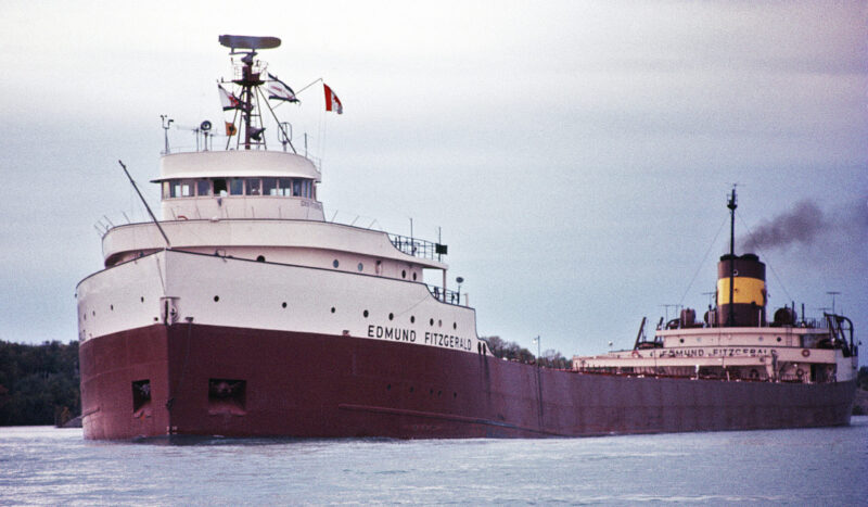 The Edmund Fitzgerald: Large ship with a dark bottom and white levels on top in the water.