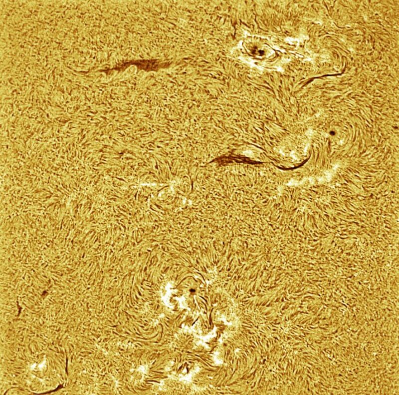 A sun close-up, seen as a flat square yellow surface with a mottled surface.