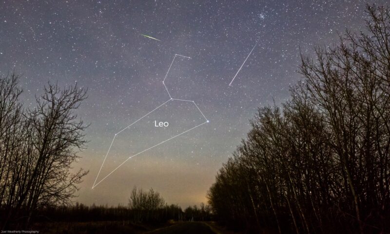 Starry sky with constellation Leo outlined, plus 2 thin streaks, one short and green and other long and white.