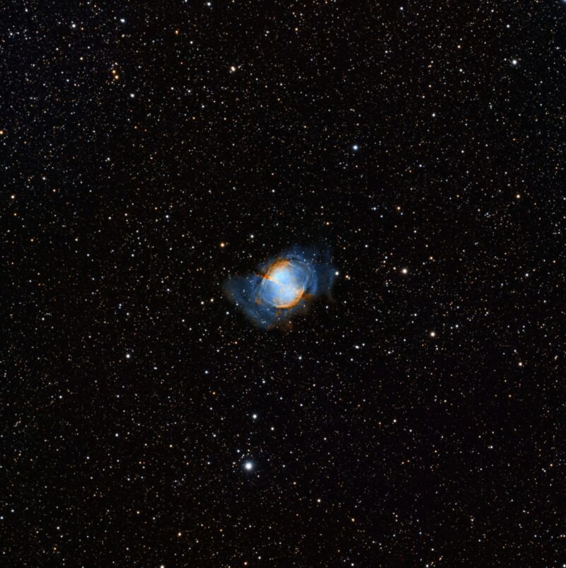 Мала, сферична чаура, наранџасте и плаве нијансе, са хиљадама звезда у позадини.