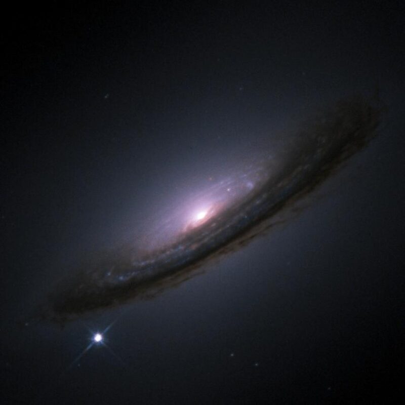Universe's expansion: A spiral galaxy with a bright point of light in the lower left.
