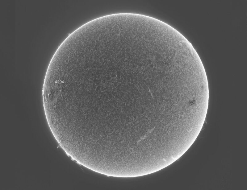 The sun, seen as a large gray sphere with a mottled surface.