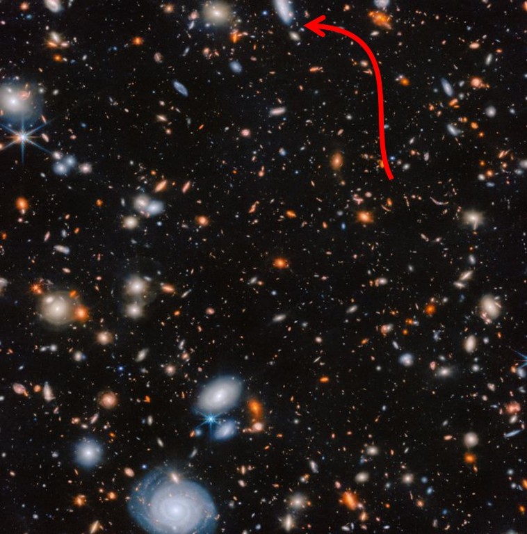 Supermassive black hole: Black background densely packed with myriads of galaxies near and far, and a red arrow pointing at a small dot.