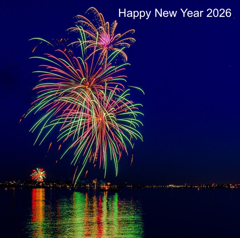 Fireworks reflecting in water with Happy New Year 2026 written on it.