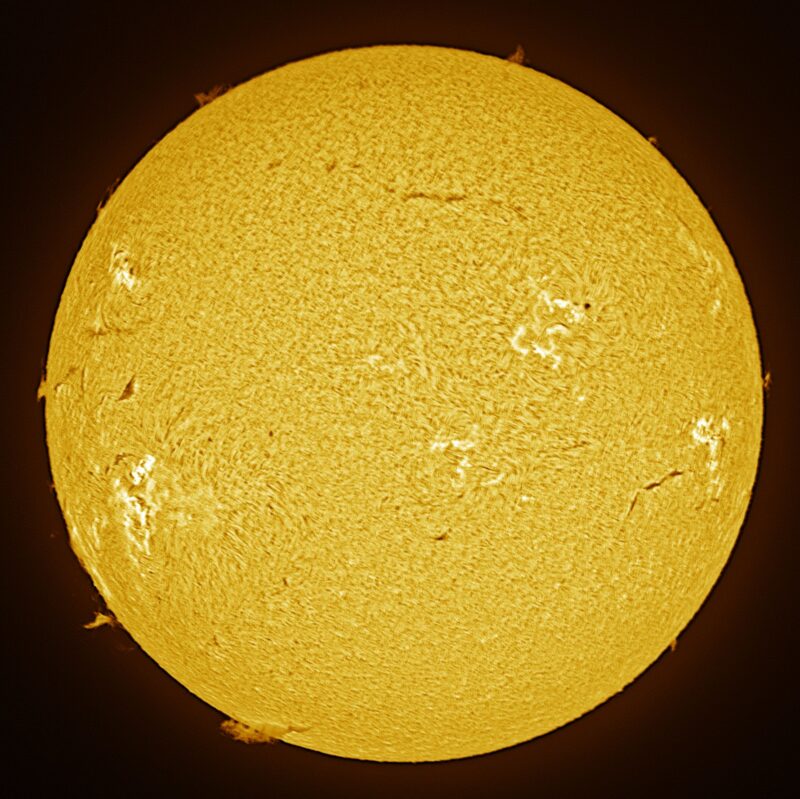 The sun, seen as a large yellow sphere with a mottled surface.