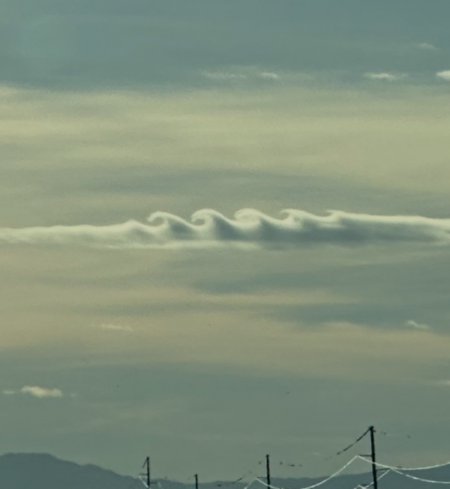 A band of clouds looking just like ocean waves seen from the side.