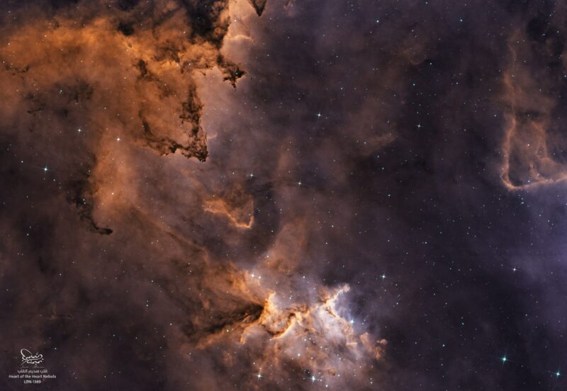 Multiple orange clouds with dark lanes in between, plus numerous faint stars.