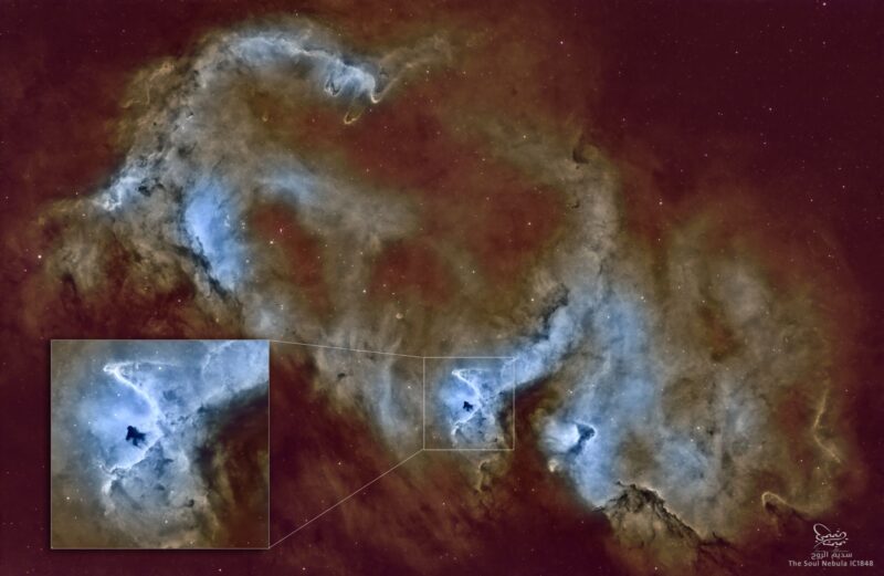 Multiple bluish patches of nebulosity with dark lanes, overlaid with a rich background of stars.