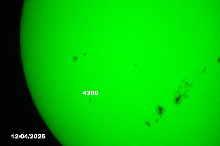 The sun, seen as a green sectional sphere with dark spots.