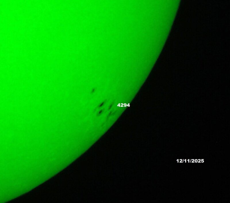 The sun, seen as a green sectional sphere with dark spots.