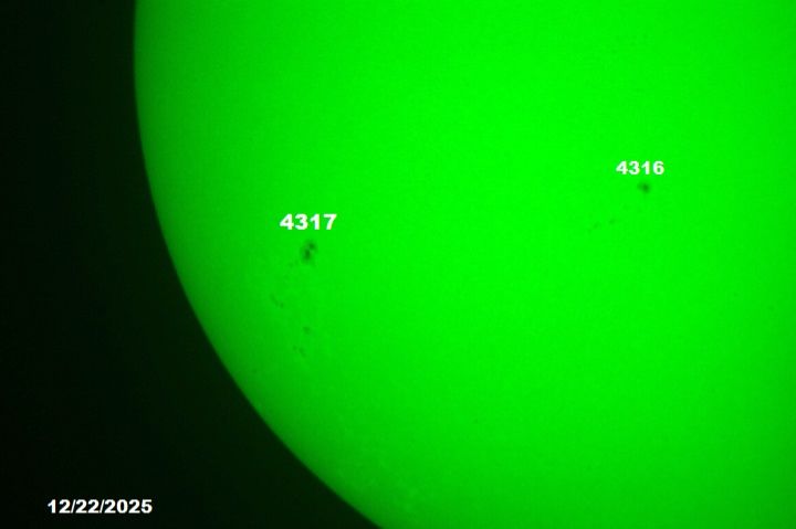 The sun, seen as a green sectional sphere with dark spots.