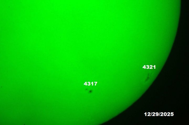 The sun, seen as a green sectional sphere with dark spots.