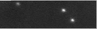 A small black and white image showing 3 dots, with 1 flashing on and off.