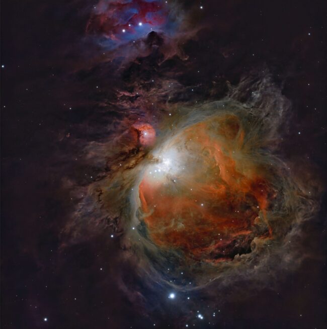 Large, bright red and blue swirls with bright stars in them over a background of prolific stars.