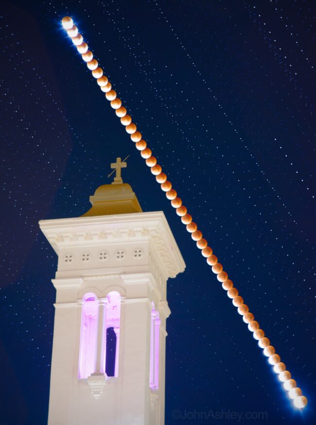 A line of eclipsed moons from lower right to upper left behind a mission tower and cross.