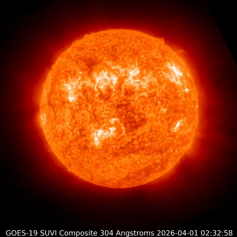 The sun as a large mottled orange and yellow ball with streamers of orange gas floating off it.