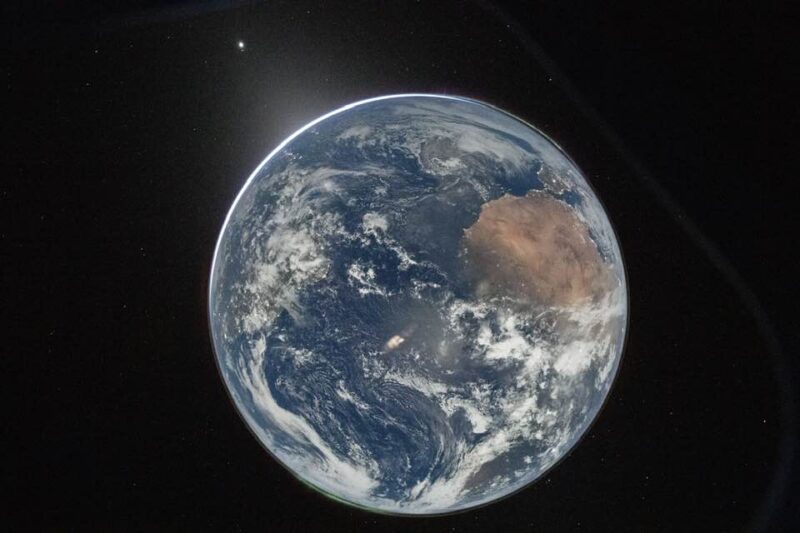 Earth in the light of a full moon. A bright dot to the top left.