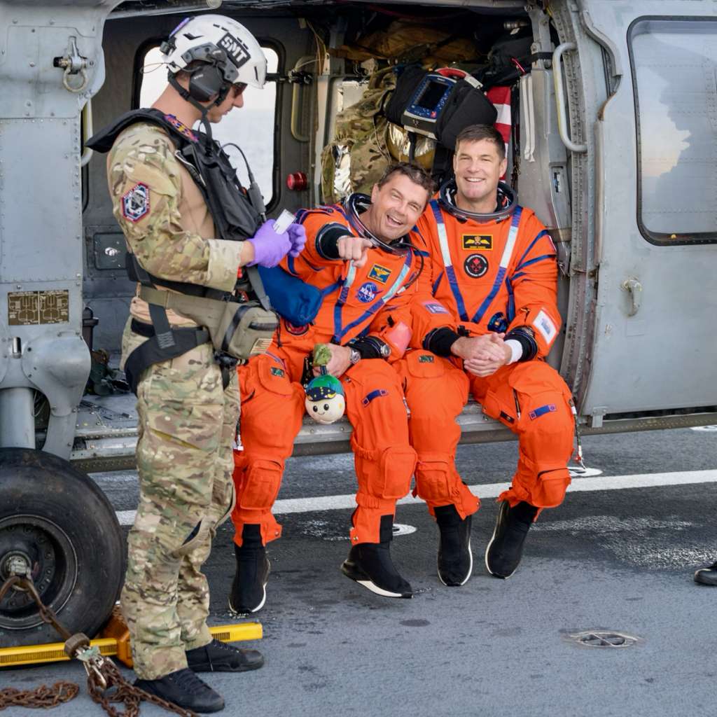 2 smiling men, one pointing at the camera.