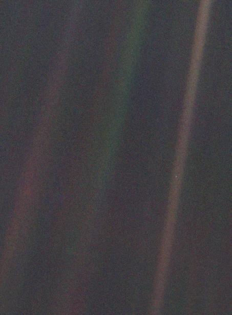 Beams of light in faded pinkish, orangish and greenish colors. There is a tiny pale dot in one of them.